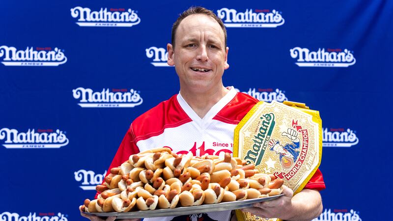 Competitive eater Joey Chestnut poses for photos with 76 hot dogs at a weigh-in before the...